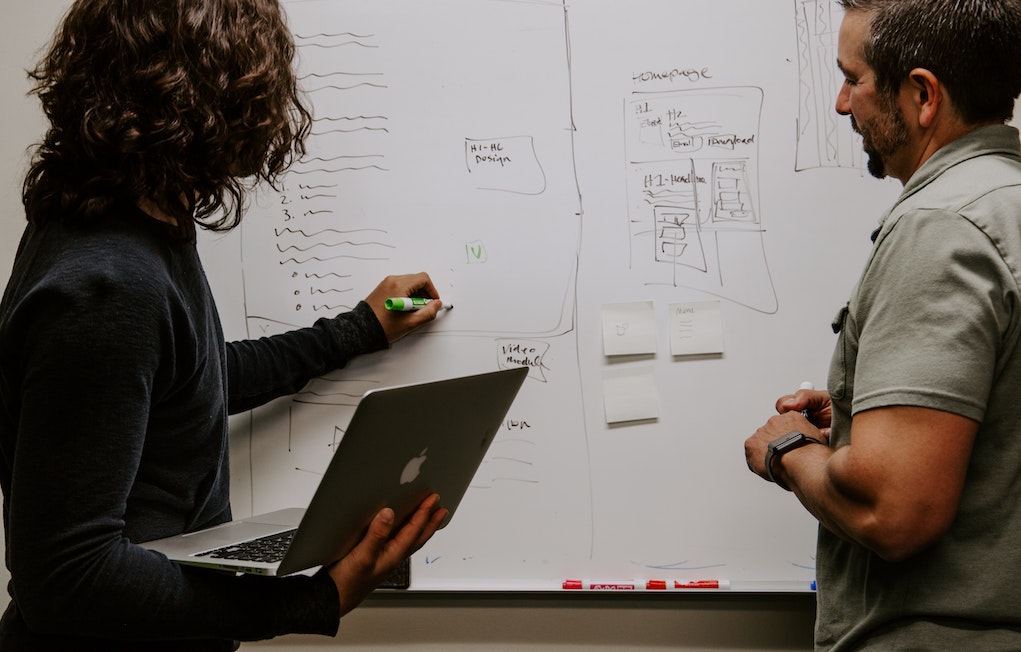 Two people at a whiteboard Two people at a whiteboard